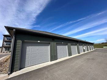 A garage with a row of garage doors and a blue sky